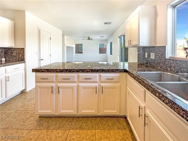 kitchen featuring visible vents, plenty of natural light, a peninsula, and a sink