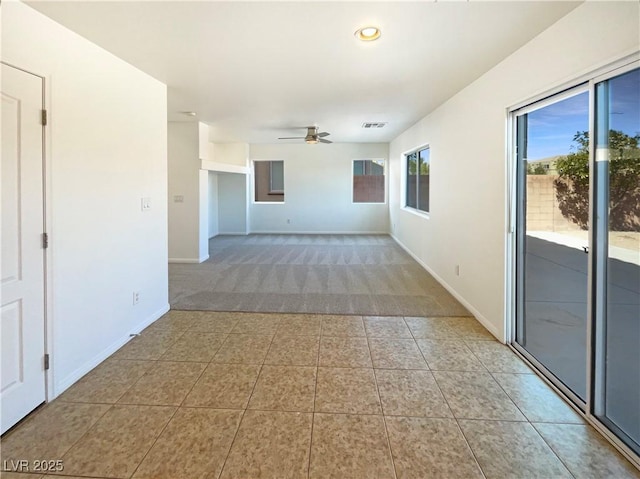 carpeted empty room featuring visible vents, recessed lighting, tile patterned flooring, baseboards, and ceiling fan