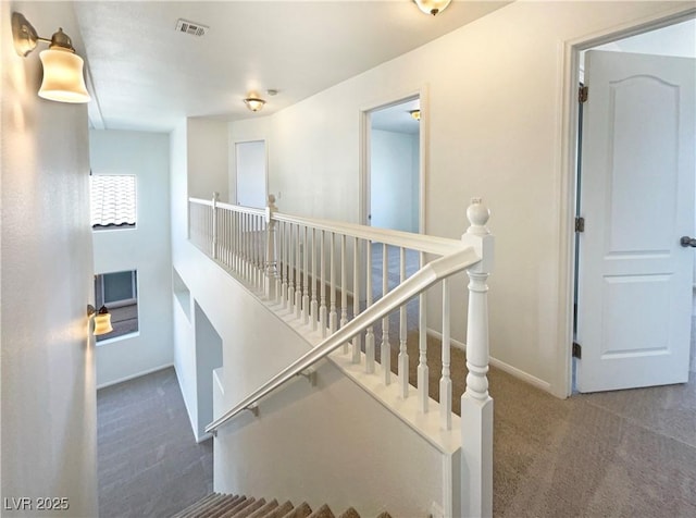 staircase with carpet flooring, baseboards, and visible vents