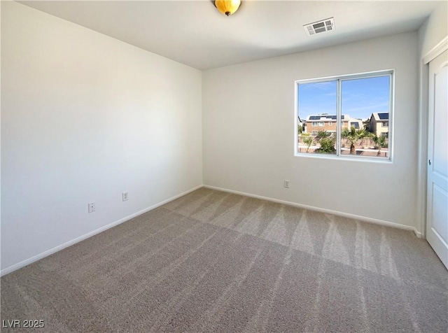 unfurnished room with visible vents, baseboards, and carpet floors