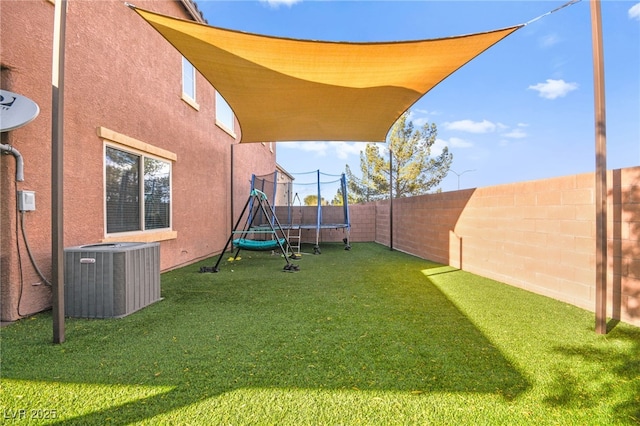 view of yard with cooling unit, a fenced backyard, and a trampoline