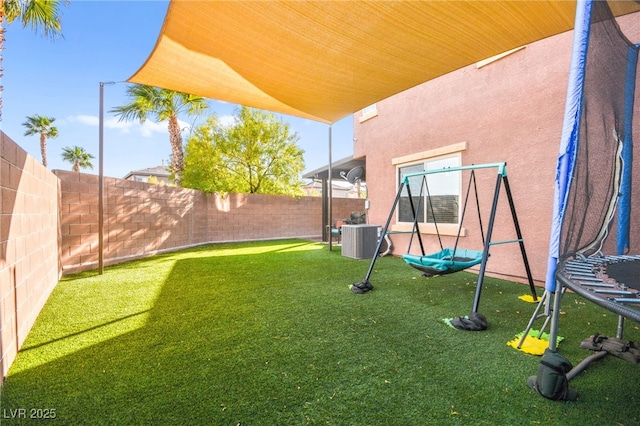 view of yard featuring central air condition unit, a trampoline, and a fenced backyard