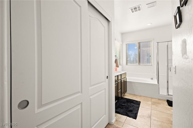 full bath featuring tile patterned flooring, a garden tub, visible vents, and a shower stall