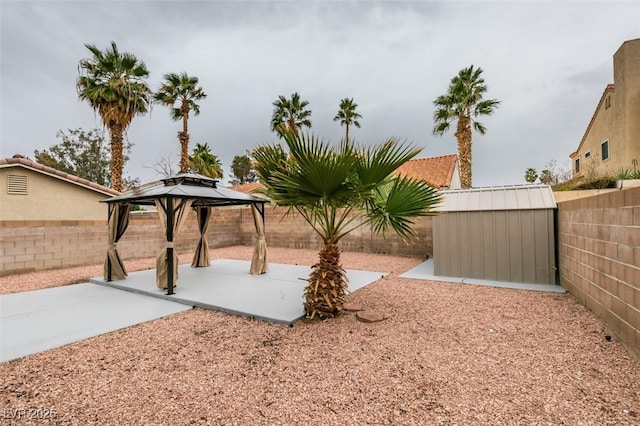 view of yard featuring a shed, a gazebo, a fenced backyard, an outdoor structure, and a patio