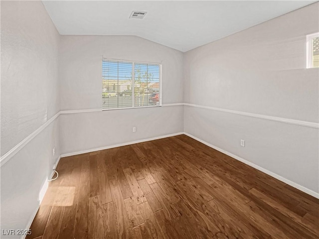 spare room featuring vaulted ceiling, wood finished floors, visible vents, and baseboards