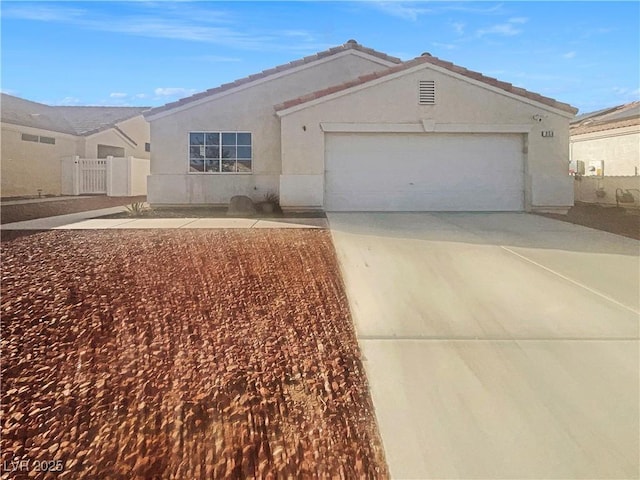 single story home featuring stucco siding, driveway, a tile roof, fence, and an attached garage