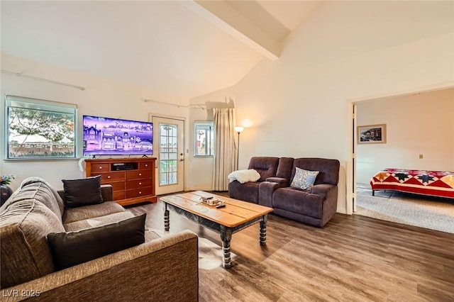 living area with beamed ceiling, wood finished floors, and high vaulted ceiling