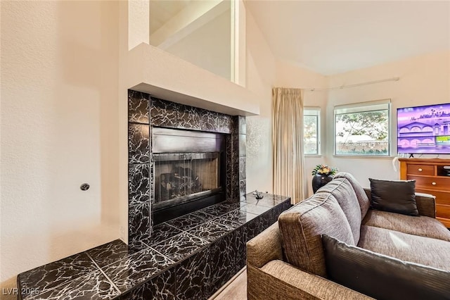 living area featuring lofted ceiling and a tile fireplace