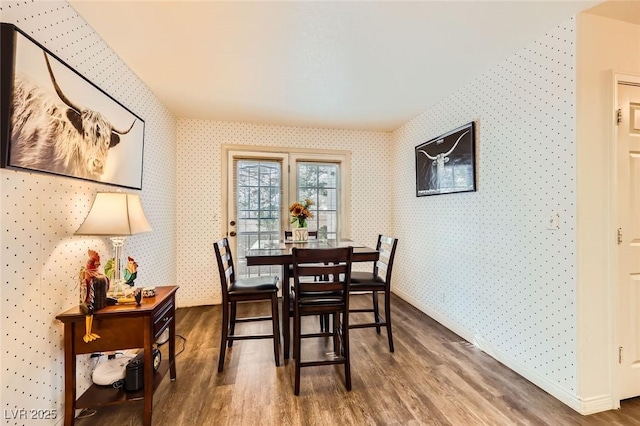 dining area with baseboards, wood finished floors, and wallpapered walls