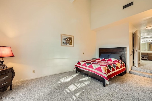 bedroom with visible vents, a towering ceiling, baseboards, and carpet floors