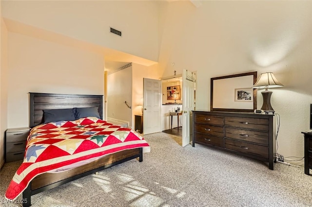 bedroom featuring a high ceiling, baseboards, visible vents, and carpet floors