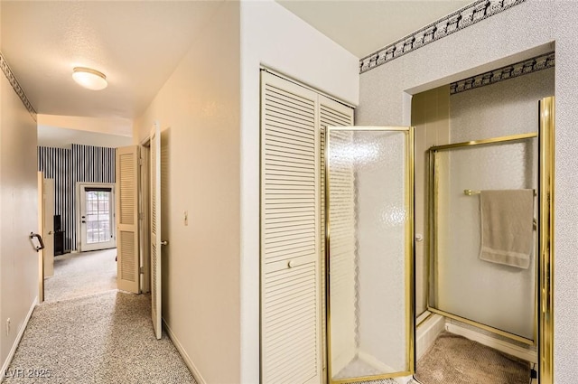 hallway with baseboards and light colored carpet