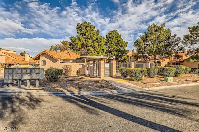 mediterranean / spanish-style house with a gate, stucco siding, and fence