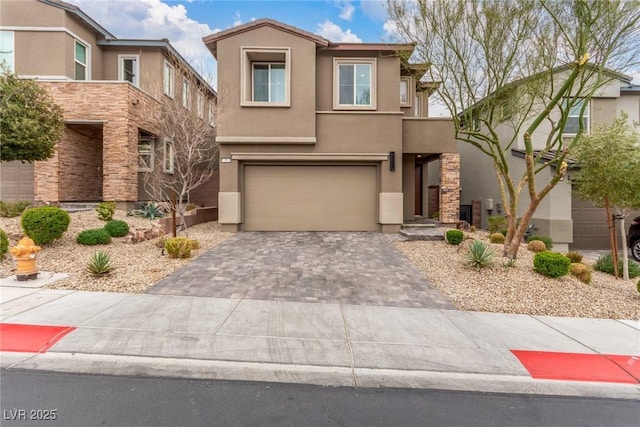 view of front of house featuring stucco siding, decorative driveway, and a garage