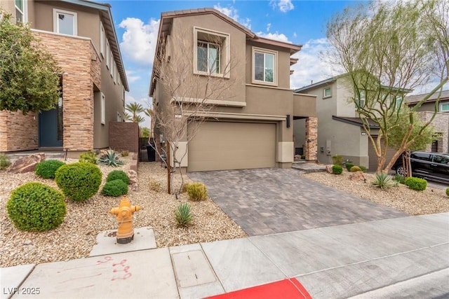 view of front facade featuring stucco siding, decorative driveway, and an attached garage