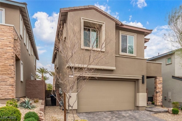 traditional-style home with stucco siding, decorative driveway, a garage, and cooling unit