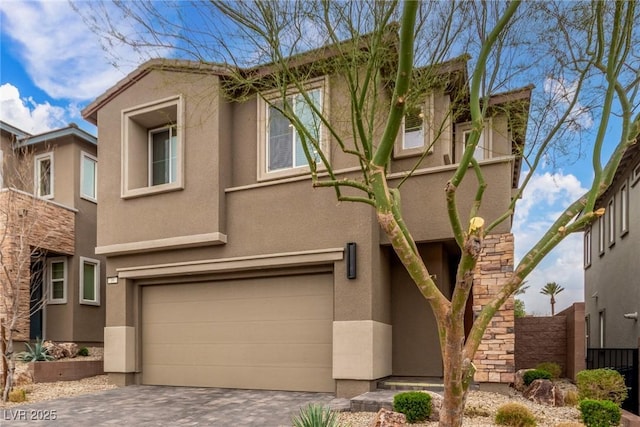 view of front of property featuring stucco siding, decorative driveway, and a garage