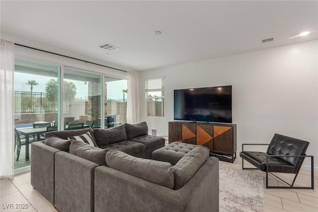 living area featuring light tile patterned floors and visible vents