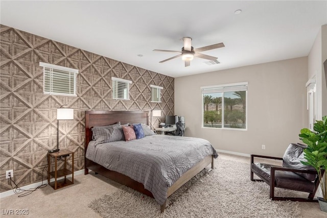 carpeted bedroom featuring visible vents, wallpapered walls, an accent wall, baseboards, and a ceiling fan