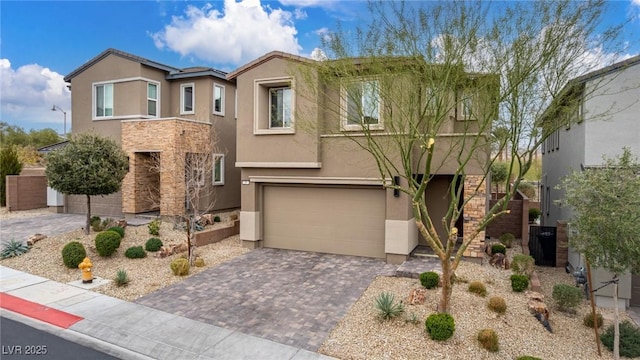 view of front of property featuring stucco siding, decorative driveway, stone siding, a garage, and stairs