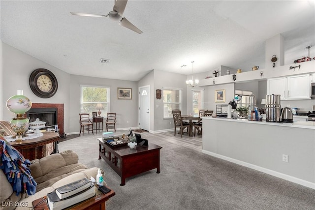 living area with baseboards, light colored carpet, vaulted ceiling, ceiling fan with notable chandelier, and a fireplace