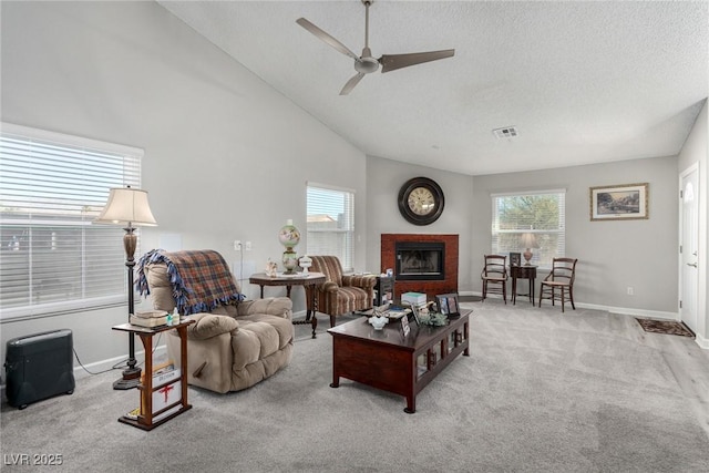 carpeted living area featuring a brick fireplace, a healthy amount of sunlight, visible vents, and baseboards