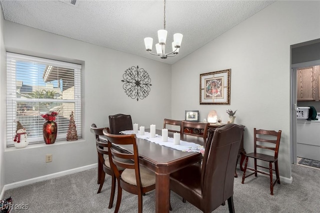 carpeted dining area with baseboards, lofted ceiling, washer / dryer, an inviting chandelier, and a textured ceiling