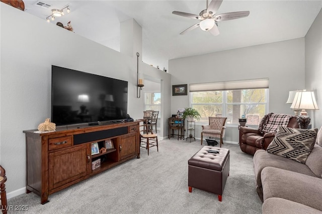 living area with ceiling fan, visible vents, baseboards, and light carpet