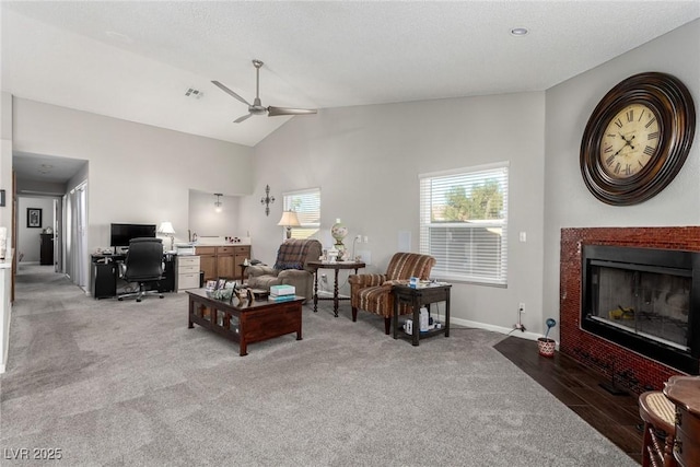 living area featuring a fireplace with flush hearth, a ceiling fan, visible vents, and light carpet