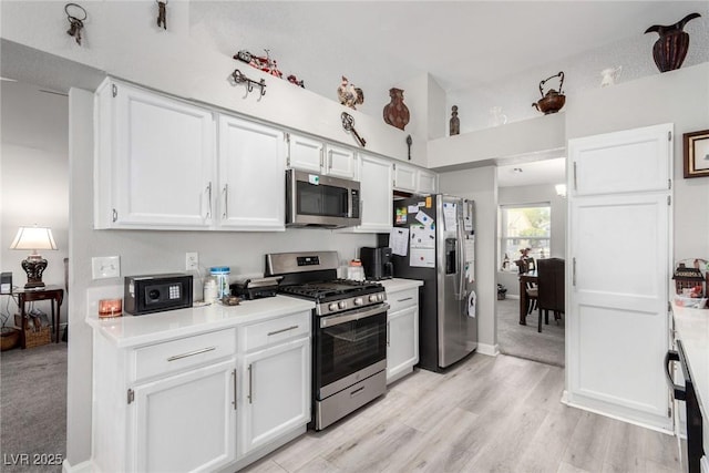 kitchen featuring white cabinets, appliances with stainless steel finishes, light wood-type flooring, and light countertops