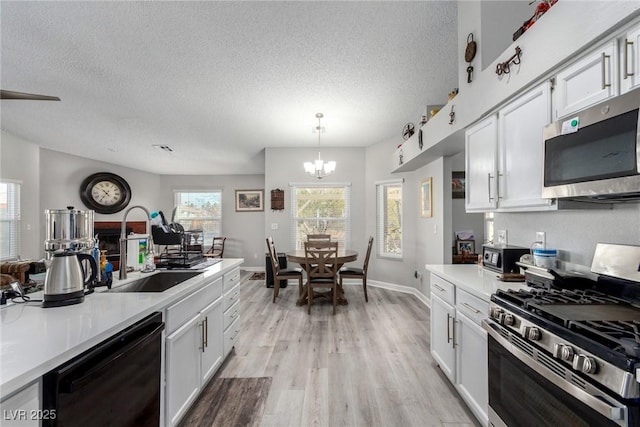 kitchen with white cabinetry, light wood-style floors, and appliances with stainless steel finishes