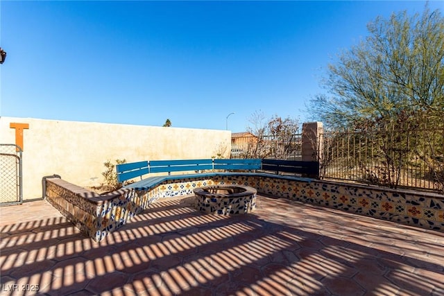 view of patio featuring an outdoor fire pit and fence