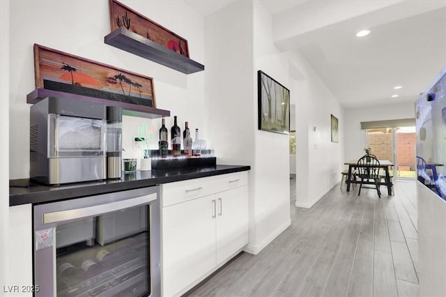 bar featuring baseboards, light wood-style flooring, recessed lighting, wine cooler, and a dry bar