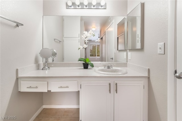 bathroom featuring tile patterned flooring, vanity, and baseboards