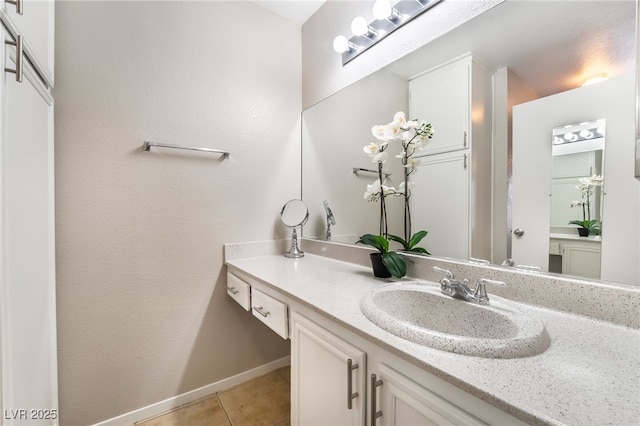 bathroom featuring tile patterned flooring, vanity, and baseboards