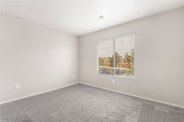 carpeted spare room featuring baseboards