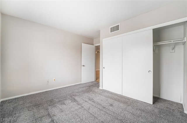 unfurnished bedroom with visible vents, carpet floors, and a closet