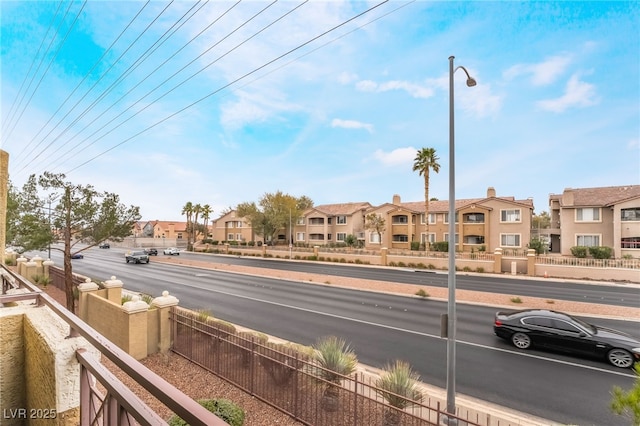 view of road featuring a residential view, street lights, and sidewalks