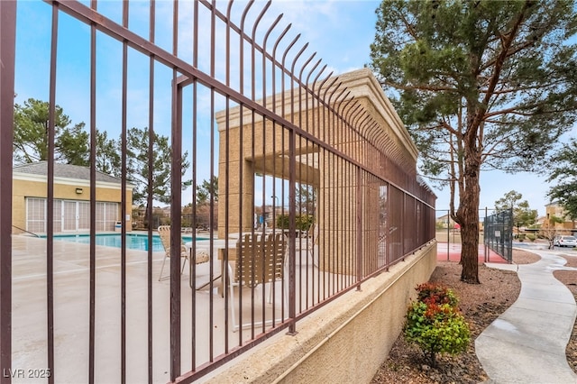 view of home's exterior with a community pool and fence