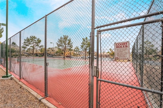 view of sport court featuring a gate and fence