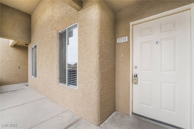 entrance to property featuring stucco siding