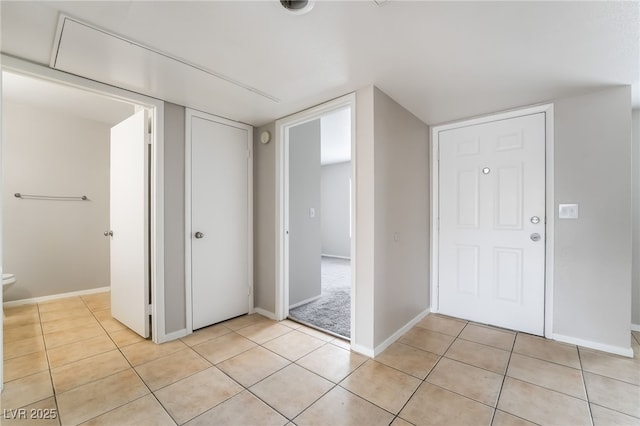 entryway with light tile patterned floors and baseboards