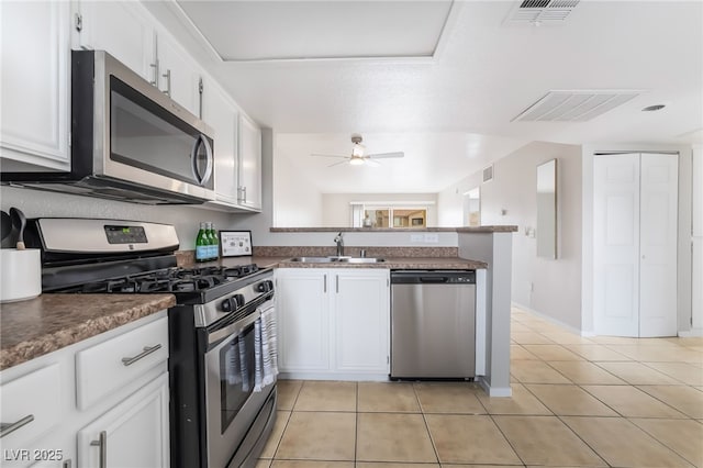 kitchen with a ceiling fan, visible vents, a peninsula, a sink, and stainless steel appliances