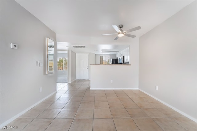 unfurnished living room featuring light tile patterned flooring, visible vents, baseboards, and ceiling fan