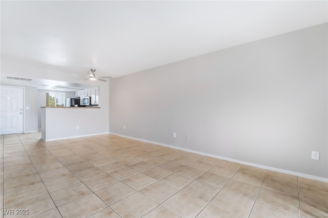 unfurnished living room with light tile patterned floors, visible vents, baseboards, and ceiling fan