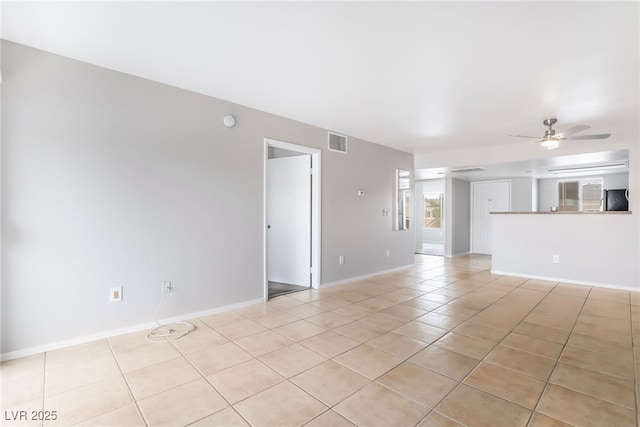 unfurnished living room with light tile patterned flooring, visible vents, baseboards, and a ceiling fan