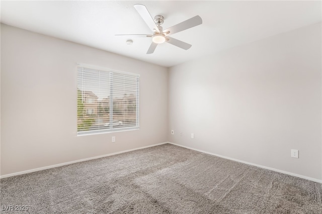 carpeted spare room featuring baseboards and a ceiling fan