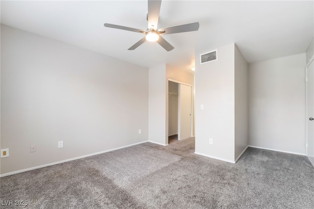 unfurnished bedroom featuring visible vents, carpet floors, baseboards, ceiling fan, and a spacious closet