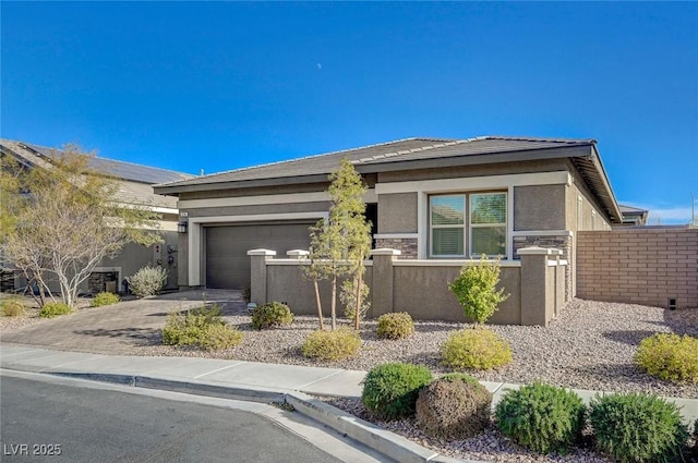 view of front of property featuring a fenced front yard, stone siding, stucco siding, and driveway