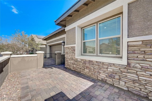 view of patio with a gate, fence, and a garage